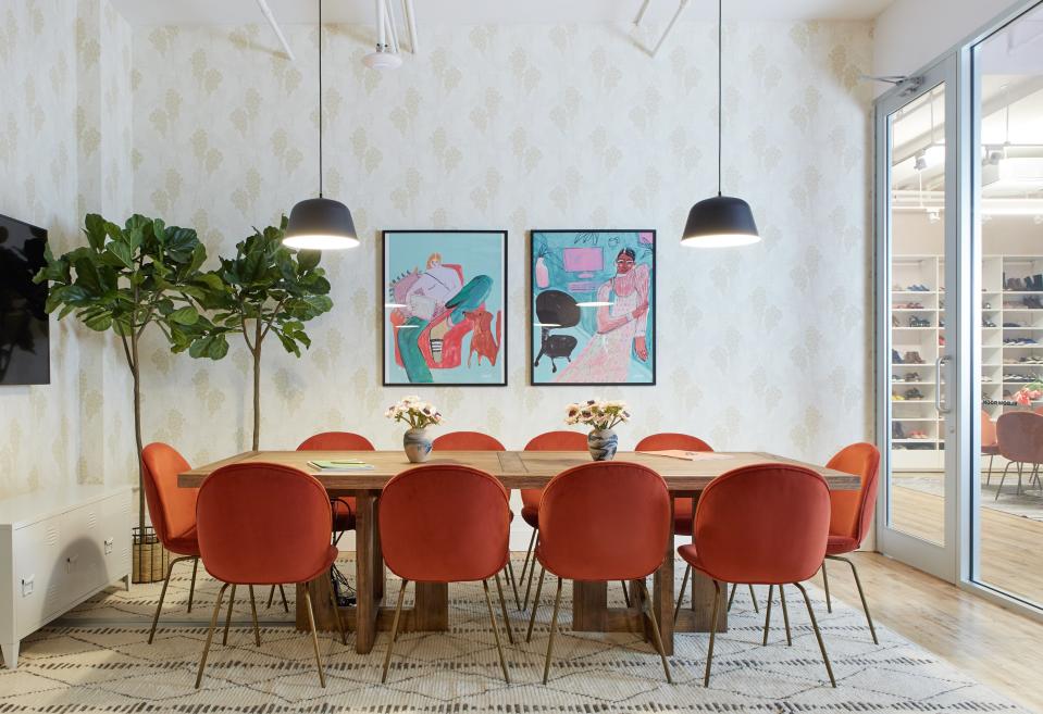 Orange velvet chairs line the conference room table—no risk of drabness here.