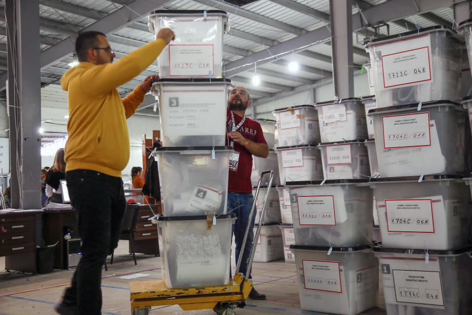 Workers carry ballot boxes at Central Election Committee counting center in Fushe Kosove, Kosovo on Monday, Oct. 7, 2019. Kosovo's opposition parties have won a snap election, overcoming the former independence fighters who have governed the country since its war 20 years ago. With 96% of the votes counted Monday the left-wing Movement for Self-Determination Party, or LVV, has 26% of the votes, one percentage point more than the conservative Democratic League of Kosovo, or LDK, also formerly in opposition. (AP Photo/Visar Kryeziu)
