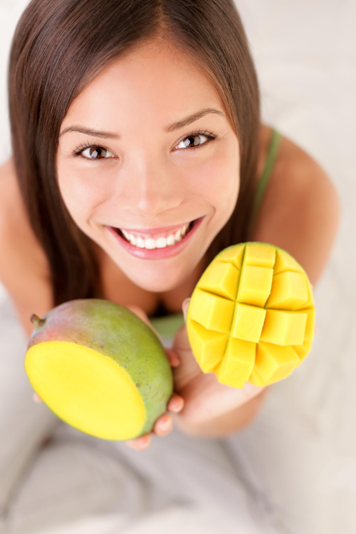 Mango fruit. Woman showing a mango fruits, cut and sliced.Tomato. Woman showing tomatoes.