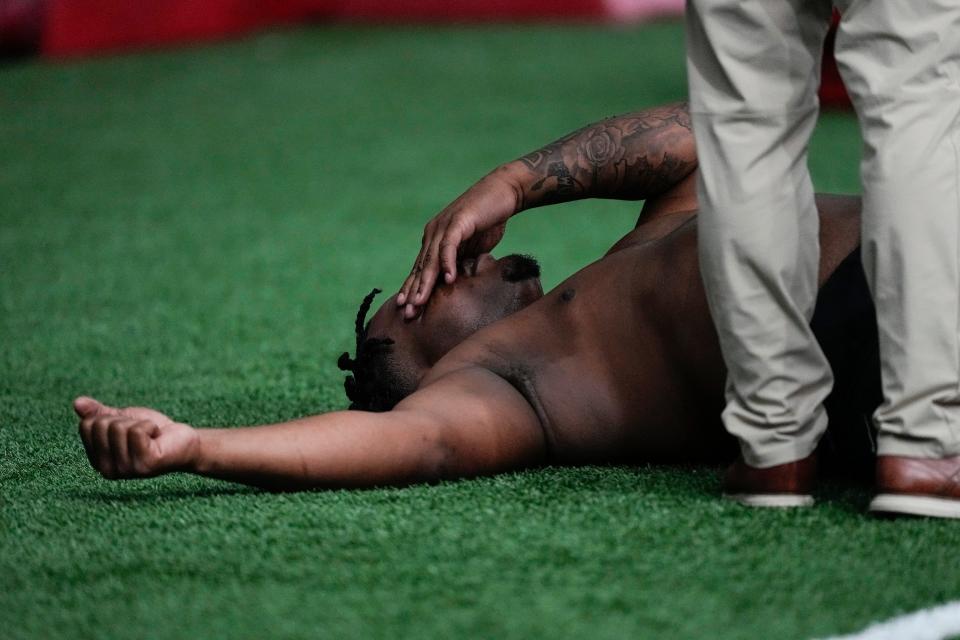 A trainer works with former Georgia defensive lineman Jalen Carter after he runs football drills during Georgia's Pro Day, Wednesday, March 15, 2023, in Athens, Ga. (AP Photo/John Bazemore)