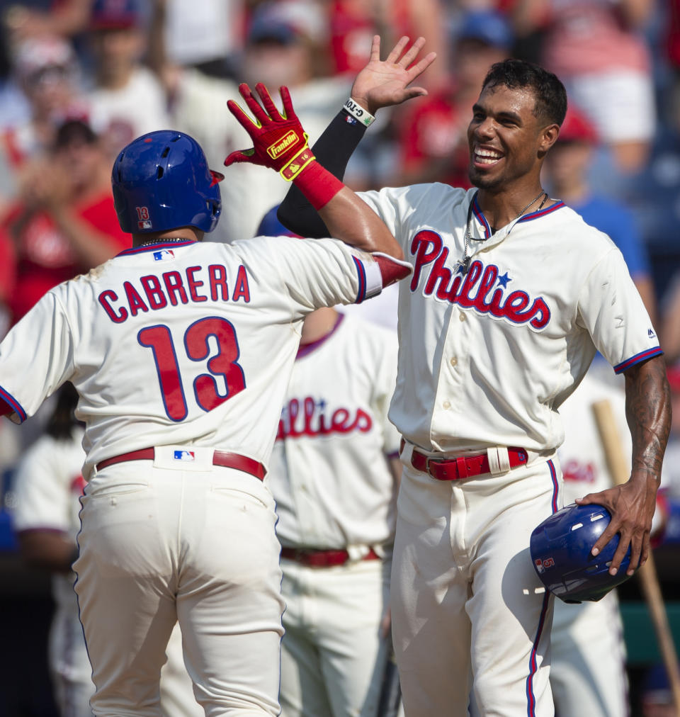 Philadelphia Phillies' Asdrubal Cabrera (13) high-fives Nick Williams after hitting a two-run home run in the eighth inning of a baseball game against the Miami Marlins, Sunday, Aug. 5, 2018, in Philadelphia. (AP Photo/Laurence Kesterson)
