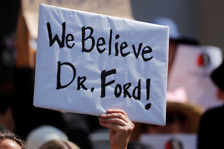 A demonstrator holds a placard outside Los Angeles City Hall to protest the Senate Judiciary committee's vote on President Trump's U.S. Supreme Court pick Brett Kavanaugh, in Los Angeles, California, U.S., September 28, 2018. REUTERS/Mike Blake