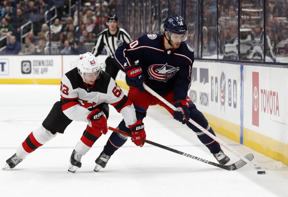 Columbus Blue Jackets forward Alexander Wennberg, right, of Sweden, chases the puck next to New Jersey Devils forward Jesper Bratt, of Sweden, during the second period an NHL hockey game in Columbus, Ohio, Saturday, Jan. 18, 2020. (AP Photo/Paul Vernon)