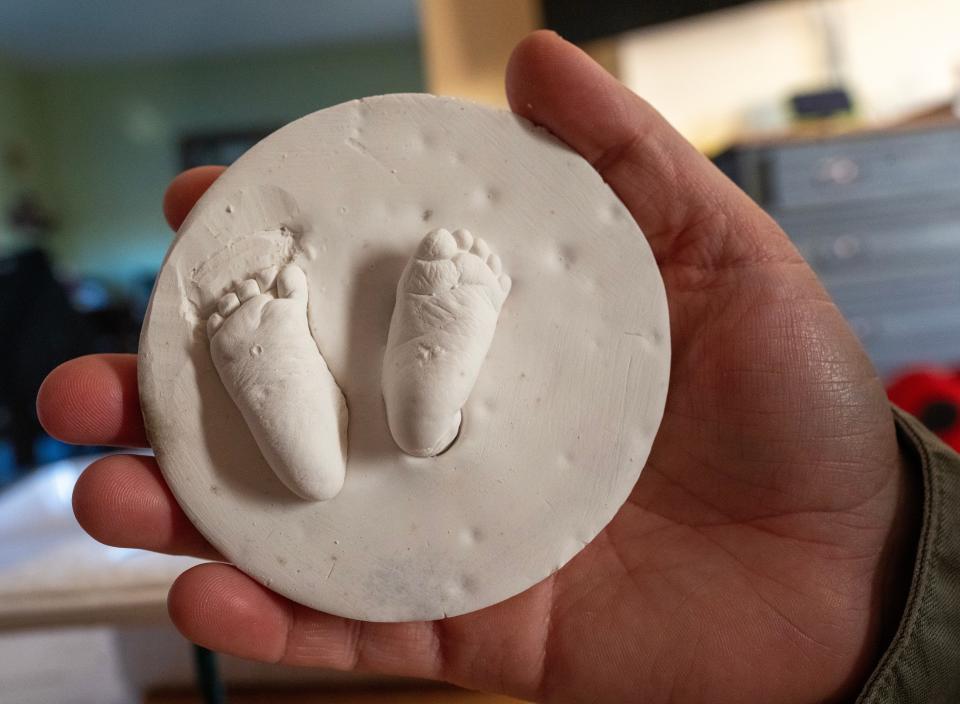 Nolan Robert Kling was nearly 1 foot long and 1 pound, 5 ounces, when he was born at 23 weeks, 2 days. He lived an hour after his birth on Nov. 10, 2023. His mother, Megan Kling, holds a cast of his footprints. (Credit: Mark Hoffman / Milwaukee Journal Sentinel)