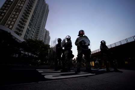 Police officers stand during a demonstration by anti-government protesters in Sha Tin