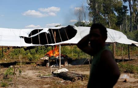 A man reacts as an illegal logging camp is burnt during "Operation Green Wave" conducted by the Brazilian Institute for the Environment and Renewable Natural Resources, or Ibama, to combat illegal logging in Apui, in the southern region of the state of Amazonas, Brazil, July 28, 2017. REUTERS/Bruno Kelly