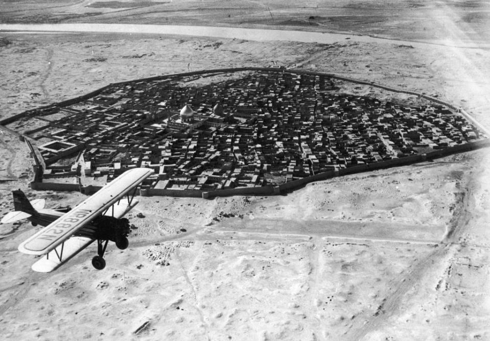 Aerial view of a smallish city surrounded by a sandy-looking, barren landscape