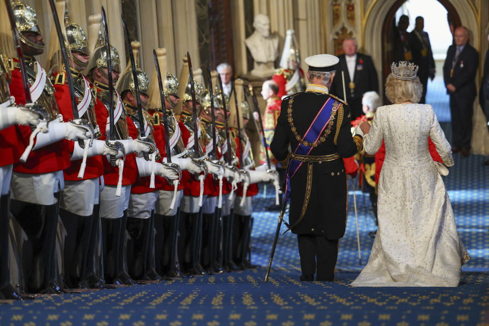 FILE - Britain's King Charles III and Queen Camilla leave after the State Opening of Parliament at the Houses of Parliament, in London, Tuesday, Nov. 7, 2023. King Charles III’s decision to be open about his cancer diagnosis has helped the new monarch connect with the people of Britain and strengthened the monarchy in the year since his dazzling coronation at Westminster Abbey. (Toby Melville/Pool Photo via AP, File)