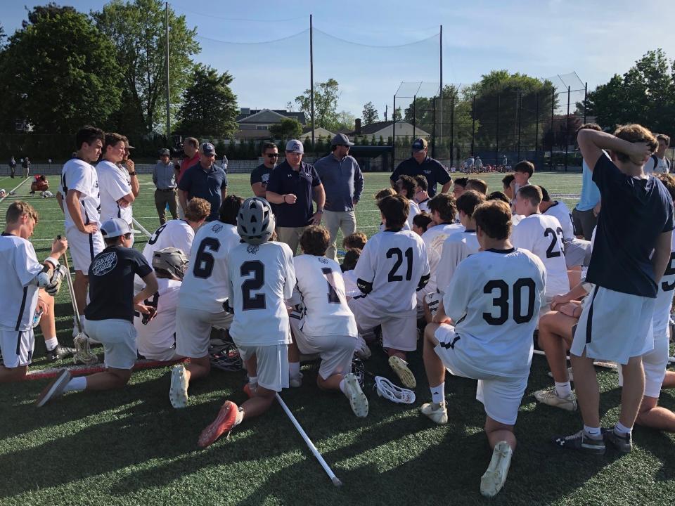 The Manasquan boys lacrosse team has a postgame chat with head coach Sean Cunningham (standing in the middle) following the team's 7-6 win over Wall on May 25, 2022.