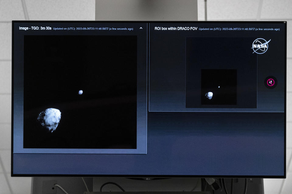 A television at NASA's Kennedy Space Center in Cape Canaveral, Florida, captures the final images from the Double Asteroid Redirection Test (DART) as it approaches asteroid Dimorphos (R), past asteroid Didymos (L), on September 26, 2022.