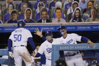 Los Angeles Dodgers' Mookie Betts (50) returns to the dugout after his solo home run, to congratulations from manager Dave Roberts, center, and bench coach Bob Geren during the ninth inning of the team's baseball game against the Arizona Diamondbacks on Wednesday, Sept. 2, 2020, in Los Angeles. (AP Photo/Marcio Jose Sanchez)