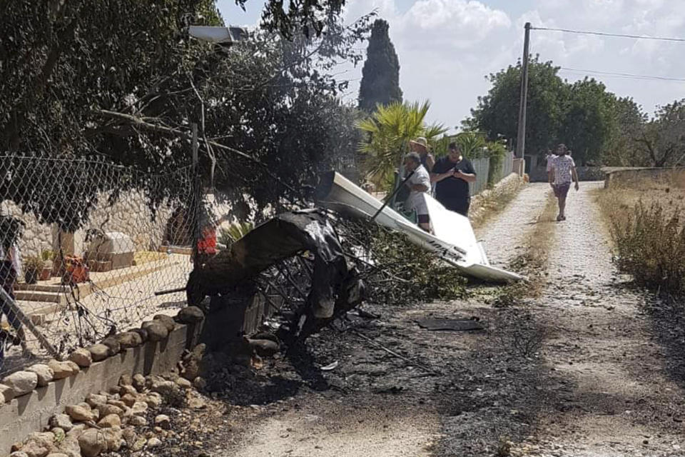 This photo provided by Incendios f.Baleares shows wreckage on a path near Inca in Palma de Mallorca, Spain, Sunday Aug. 25, 2019. Authorities in Mallorca say at least 5 people have died in a collision between a helicopter and a light plane on the Spanish island. (Incendios f.Baleares via AP)