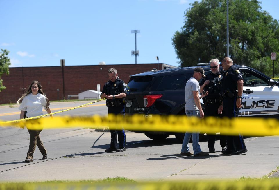 Police talk at the scene of an officer-involved shooting on Monday, July 11, 2022, at the H2Ose It car wash on Cleveland Avenue in Sioux Falls.