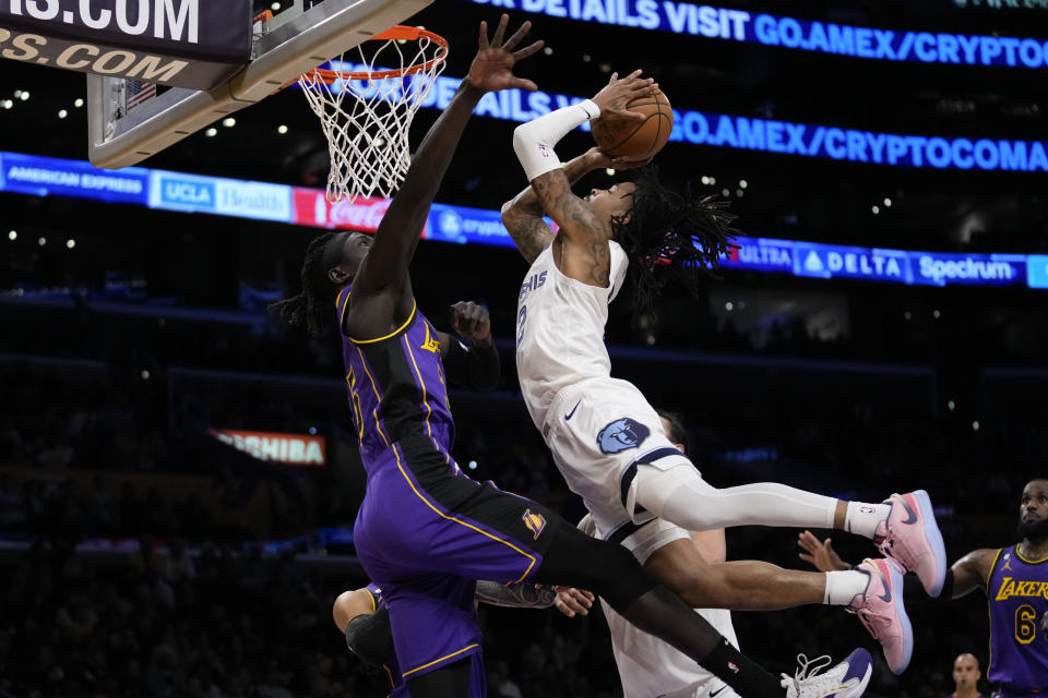 Memphis Grizzlies guard Ja Morant (12) shoots against Los Angeles Lakers forward Wenyen Gabriel (35) during the first half of an NBA basketball game in Los Angeles, Friday, Jan. 20, 2023. (AP Photo/Ashley Landis)