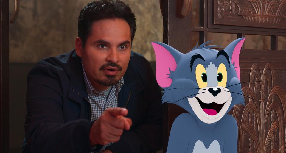 Michael Peña pointing while standing next to the animated character Tom from Tom and Jerry