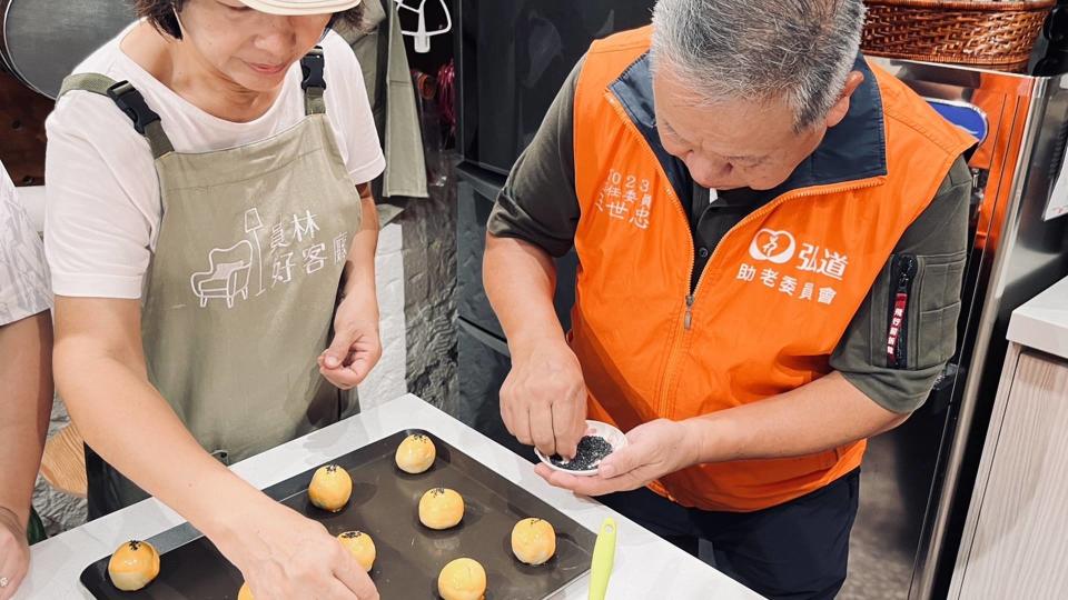 ▲烘焙點心手汪淑玲(左)現場示範蛋黃酥製作過程。（弘道基金會提供）