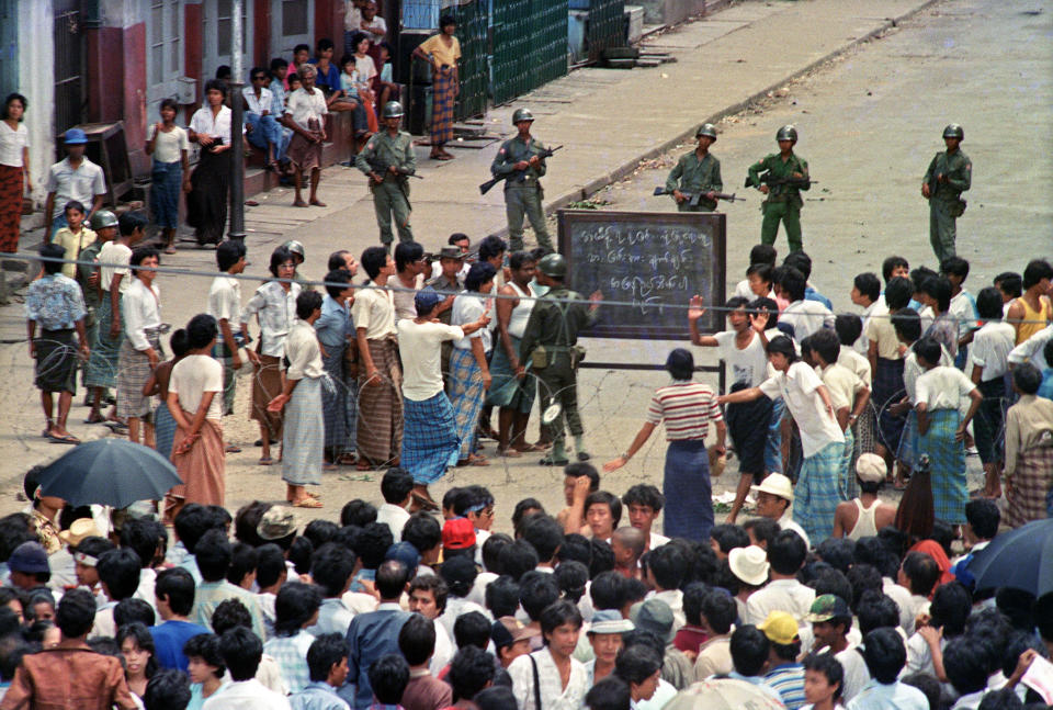 Troops order a crowd 26 Aug. 1988 in downtown Rangoon (Yangon) to disperse in front of sule pagoda sealed off by barbed wires.
