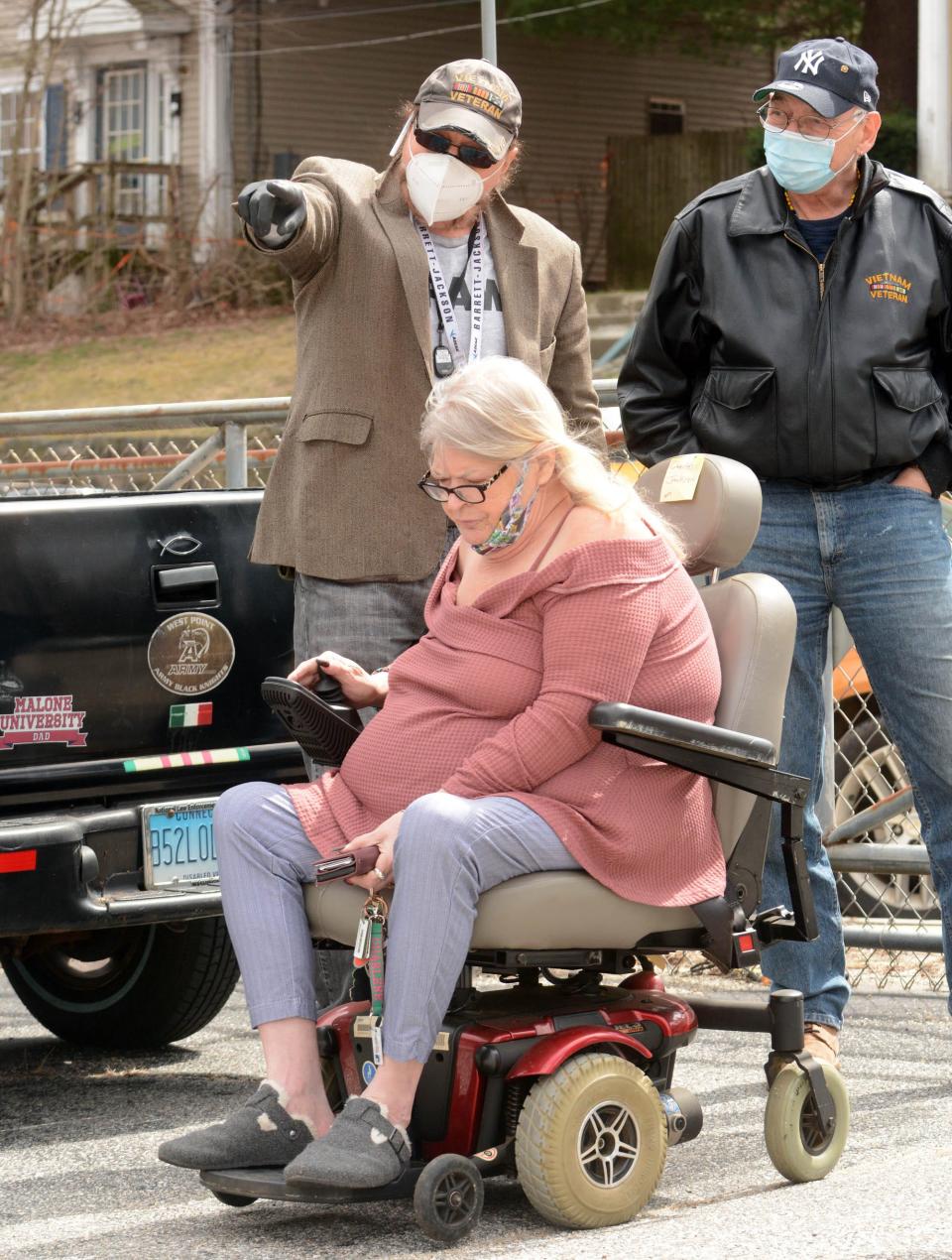 In this file photo, Charlene Jackson, 65, of Norwich tries out her refurbished motorized wheelchair given to her by Phil Pavone, left, owner of AZ Pawn in Norwich. At right is Dominick Cortese, who waits to drive her home.