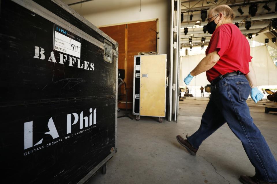 A masked man strides past L.A. Phil equipment