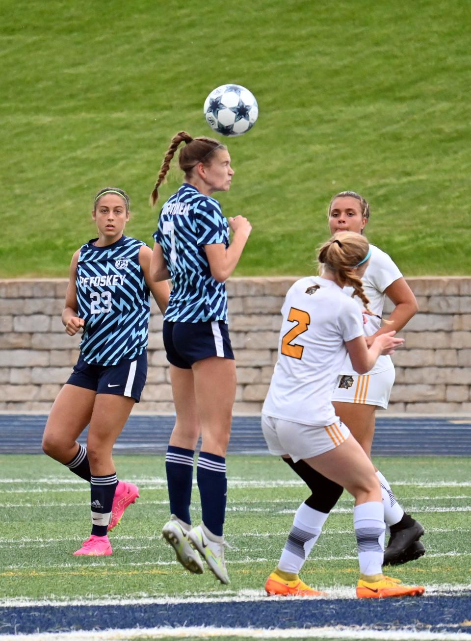Petoskey's Sydney Hoffman elevates and heads the ball over a TC Central player and out of the Northmen end of the field Tuesday at Northmen Stadium.