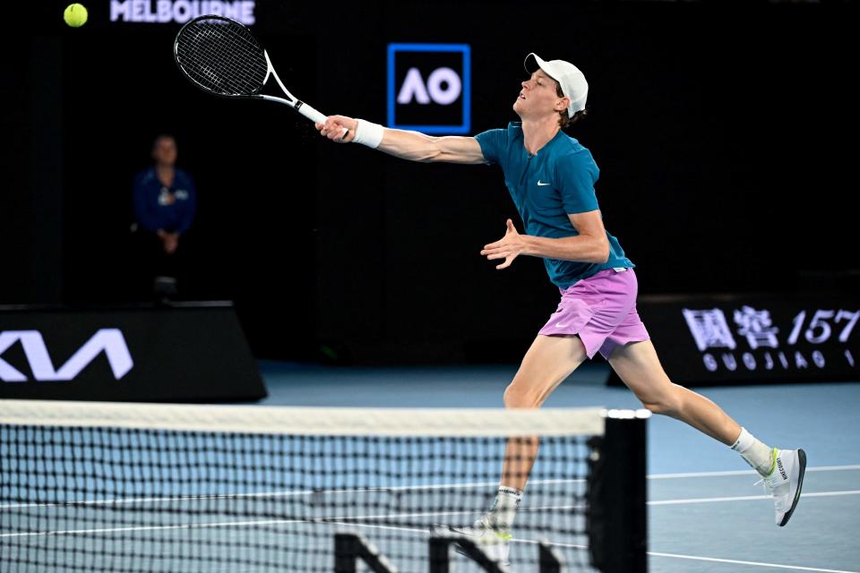 Jannik Sinner reaches for a volley at the net (AFP via Getty Images)