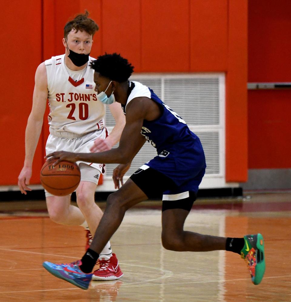 Leominster's Warren Acceus moves past St. John's Brady Collins on his way to the basket.