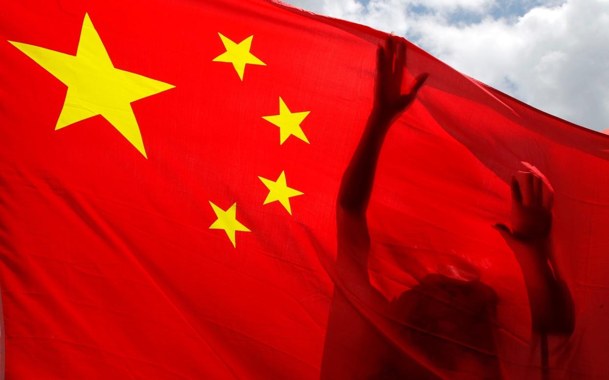 A pro-China supporter holds a Chinese national flag during a rally to celebrate the approval of a national security law for Hong Kong, in Hong Kong, Tuesday, June 30, 2020.  - Kin Cheung/AP