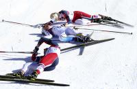 First placed Marit Bjoergen (bottom) of Norway, her team mate and fourth placed Therese Johaug (top) and second placed Charlotte Kalla of Sweden react after competing in the women's skiathlon event at the Sochi 2014 Winter Olympics in Rosa Khutor February 8, 2014. REUTERS/Sergei Karpukhin (RUSSIA - Tags: SPORT OLYMPICS SPORT SKIING)