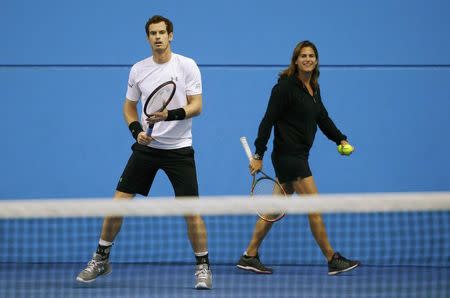 Britain's Andy Murray takes part in a practice session as his coach Amelie Mauresmo walks past at the Australian Open tennis tournament at Melbourne Park, Australia, January 22, 2016. REUTERS/Jason O'Brien