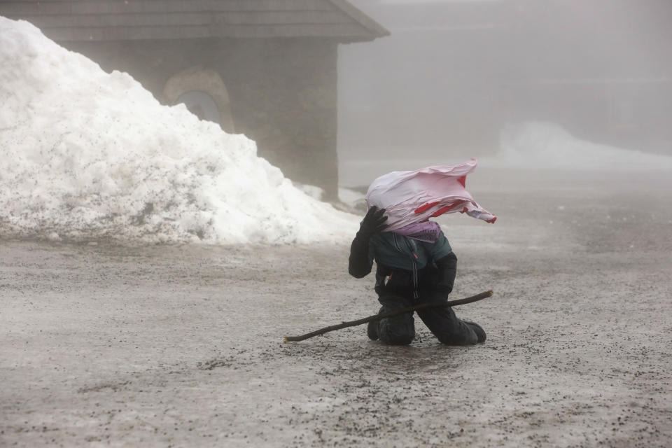 A young hiker struggles against strong wind on the mountain Brocken near Schierke, Germany, Wednesday, Feb. 16, 2022. (Matthias Bein/dpa via AP)