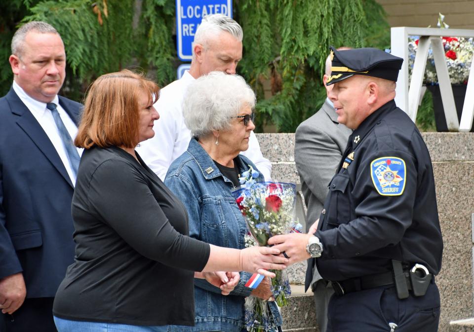 Lebanon County Sheriff Jeffrie Marley gives flowers to Lora Lebo Tuesday to recognize her husband's service in the Lebanon City Police Department. Lt. William Lebo was shot and killed in the line of duty March 31, 2022.