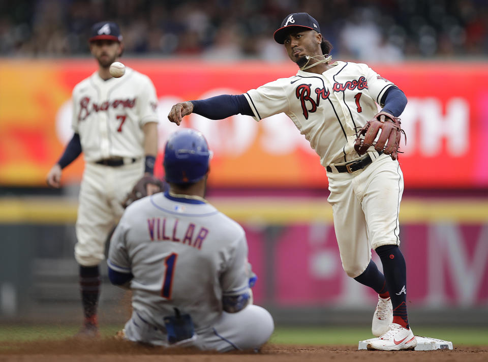 Atlanta Braves' Ozzie Albies, right, throws over New York Mets' Jonathan Villar (1) to complete a double play in the fifth inning of a baseball game Sunday, Oct. 3, 2021, in Atlanta. Mets' Jose Peraza was out at first base. (AP Photo/Ben Margot)