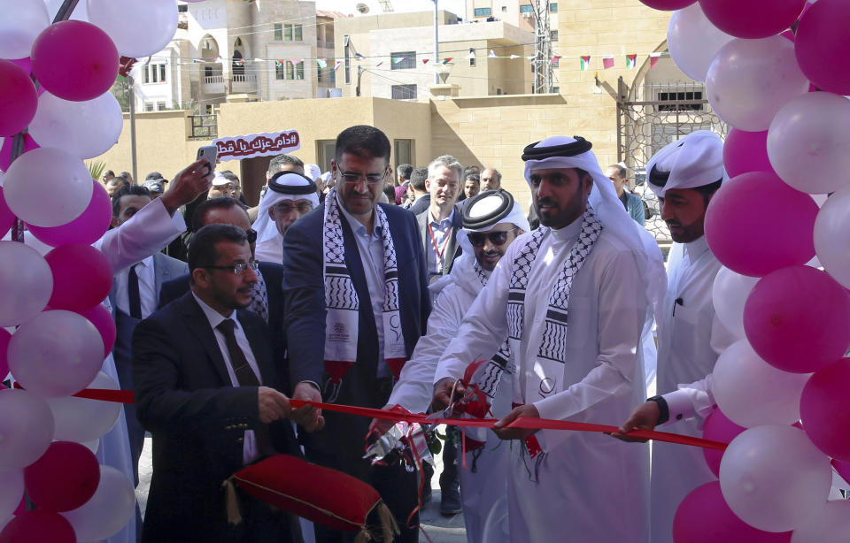Khalifa al-Kuwari, second right, director of the Qatar Fund for Development, cuts the ribbon during the opening ceremony of new Sheikh Hamad bin Khalifa Al Thani Hospital for Rehabilitation and Artificial limbs in Gaza City, Monday, April 22, 2019. Qatar inaugurated the Gaza Strip's first prosthetic hospital and disability rehab center after many delays. Health officials say the 100-bed hospital is vital for Gaza, where more than 130 Palestinians have lost limbs over the past year during ongoing protests along Gaza-Israel perimeter fence. (AP Photo/Adel Hana)