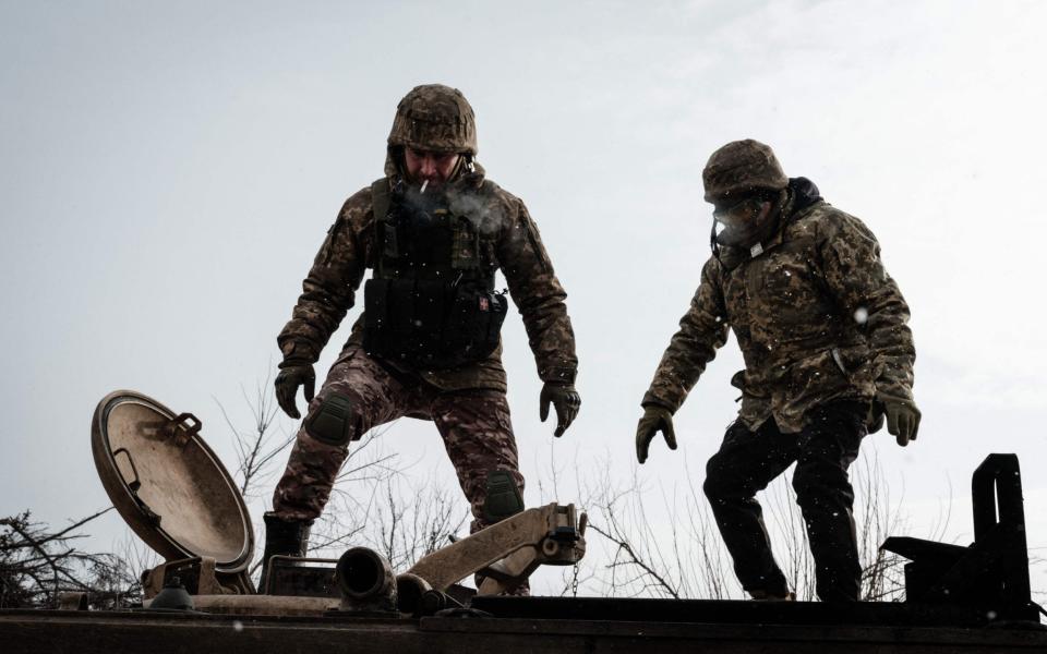 Ukrainian servicemen stand atop an M113 armoured personnel carrier in Zarichne - YASUYOSHI CHIBA / AFP