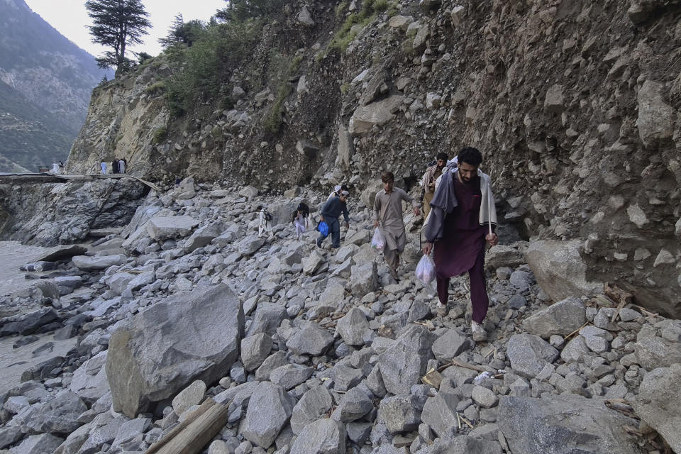 Local residents cross a portion of road destroyed by floodwaters in Kalam Valley in northern Pakistan, Tuesday, Aug. 30, 2022. Officials in Pakistan raised concerns Wednesday over the spread of waterborne diseases among thousands of flood victims as flood waters from powerful monsoon rains began to recede in many parts of the country. (AP Photo/Sherin Zada)