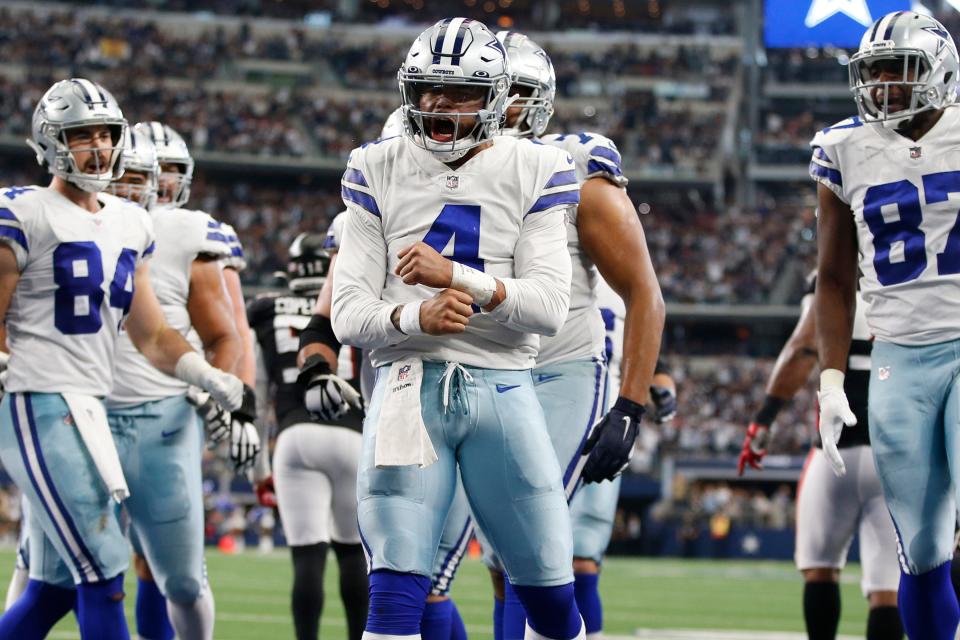 Dallas Cowboys quarterback Dak Prescott (4) celebrates scoring a touchdown in the third quarter against the Atlanta Falcons at AT&T Stadium.