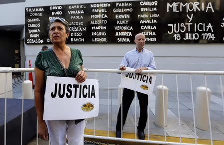 People hold signs that read "Justice" outside the AMIA Jewish community center before a demonstration to demand justice over the death of Argentine prosecutor Alberto Nisman in Buenos Aires January 21, 2015. REUTERS/Enrique Marcarian