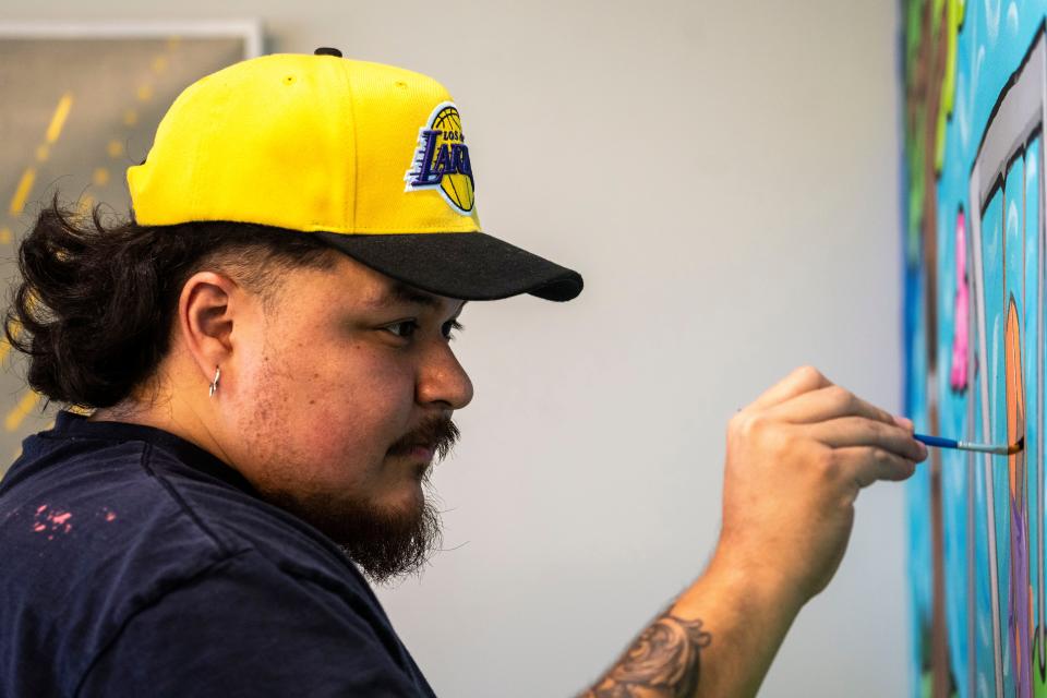 Siriaco "Siricasso" Garcia paints a mural at Midwest Autism Center on Nov. 16, 2023, in West Des Moines.