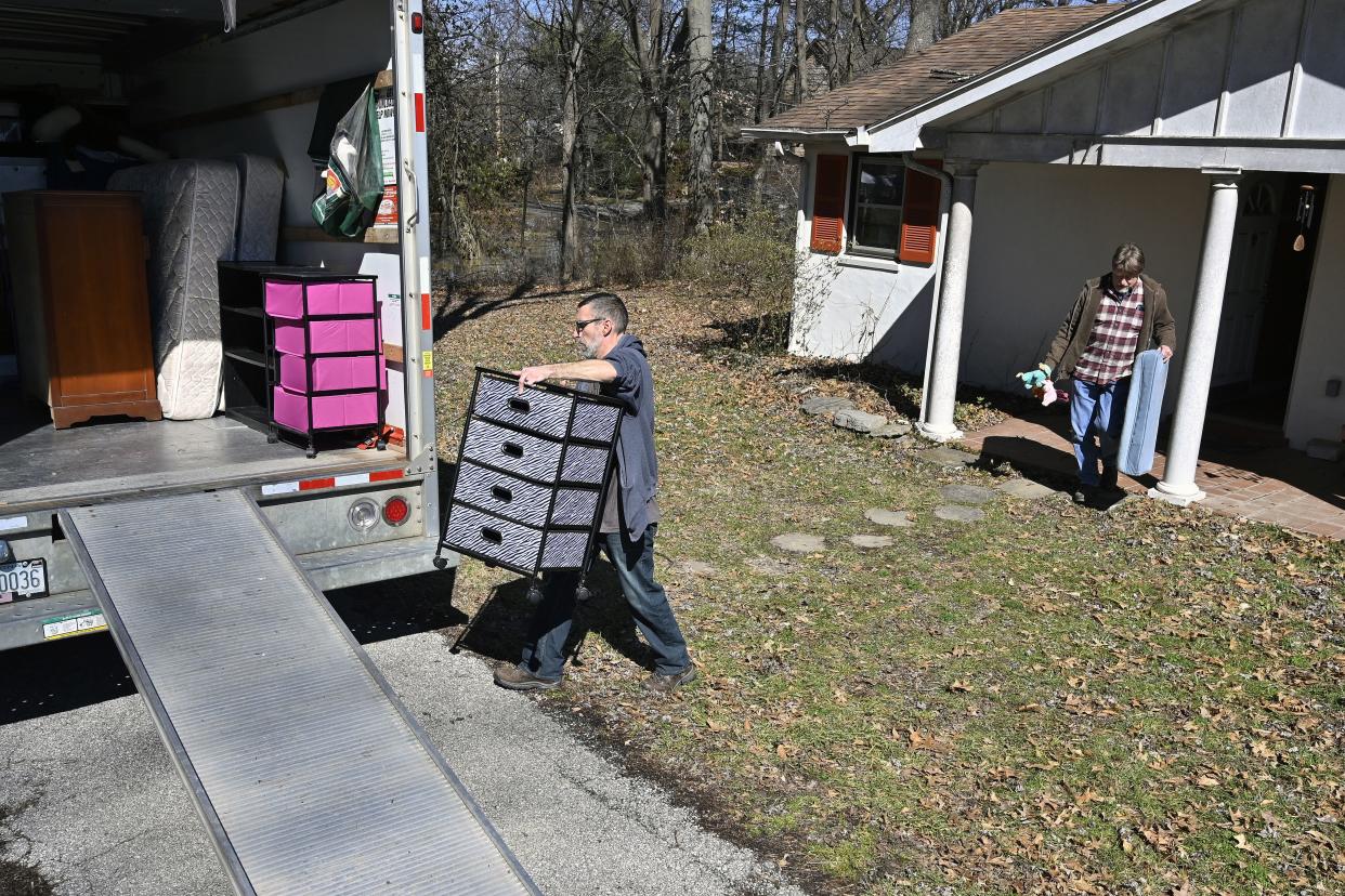 Tanner Ryles, center, and Ray Smith help move the furniture from their friend Kelly Sparrow's home as the Kentucky River inches closer in Frankfort, Ky., on Tuesday.
