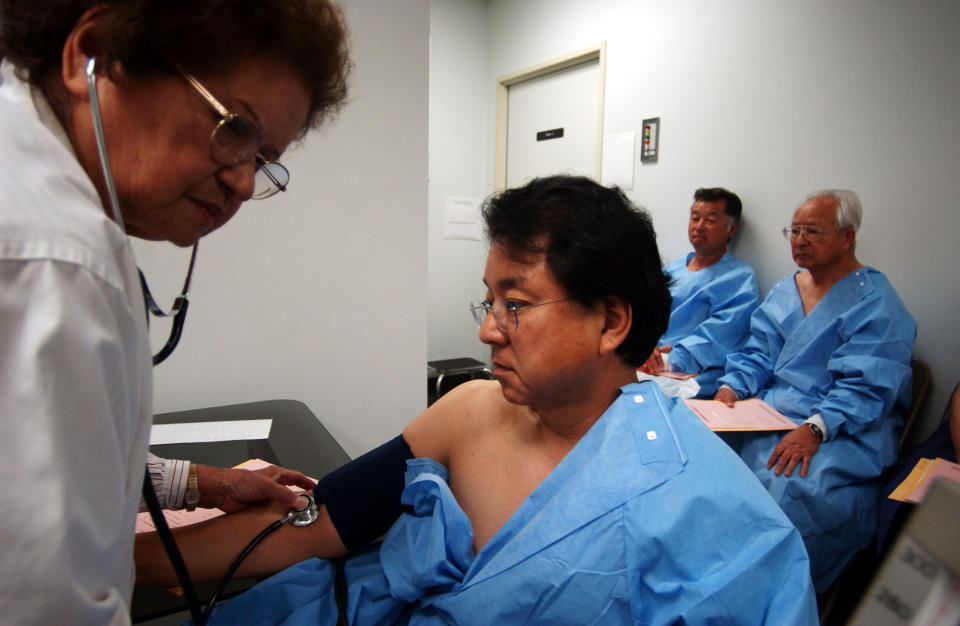 Mary Isa records the blood pressure of Glenn Yamada, whose mother survived the explosion of an atomic bomb over Hiroshima, Japan by the United States during World War II, on June 22, 2003, in Los Angeles, California.<span class="copyright">David McNew—Getty Image</span>