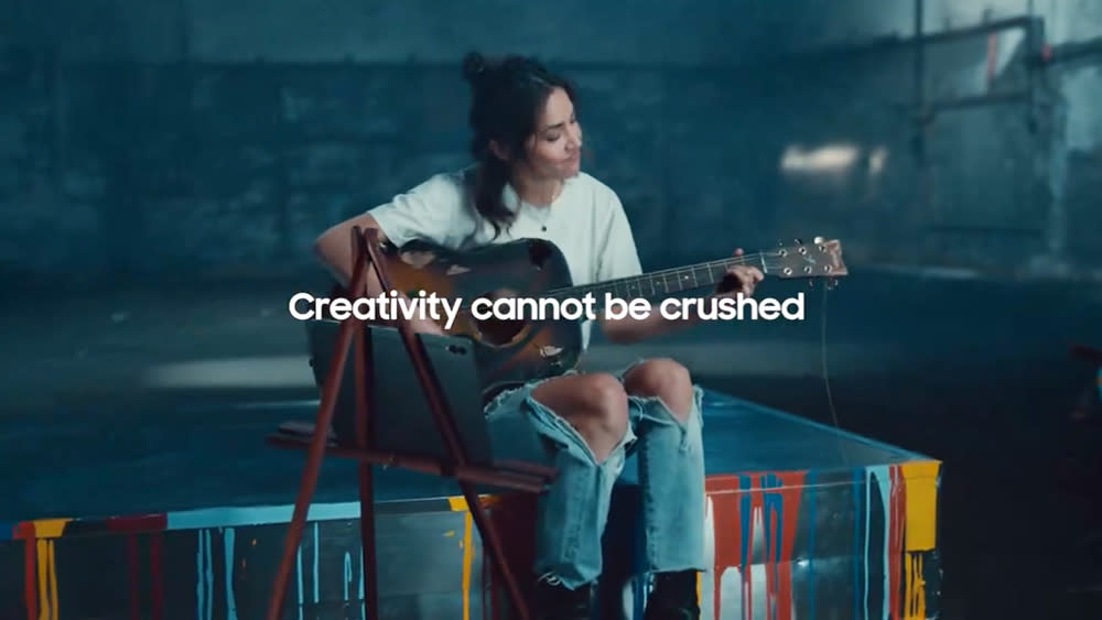  Screenshot of a girl playing guitar from a Samsung advert. 