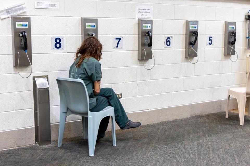 An incarcerated person makes a phone call from a female dorm.