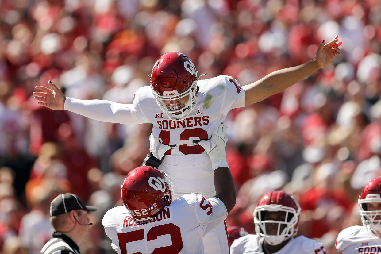 DALLAS, TEXAS - OCTOBER 09: Tyrese Robinson #52 of the Oklahoma Sooners celebrates with Caleb Williams #13 of the Oklahoma Sooners after a touchdown in the first half against the Texas Longhorns during the 2021 AT&T Red River Showdown at Cotton Bowl on October 09, 2021 in Dallas, Texas. (Photo by Tim Warner/Getty Images)