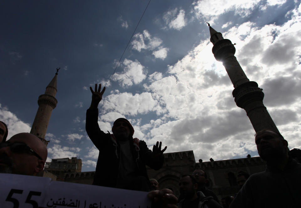 A protester affiliated with Jordan's Muslim Brotherhood against U.S. Secretary of State John Kerry's peace talks chants anti-Israel and anti-America slogans during a demonstration in downtown Amman, Jordan, Friday, Feb. 14, 2014. The gesture of showing an open palm with four raised fingers has become a symbol of the Rabaah al-Adawiya mosque, where supporters of Egypt's ousted President Mohammed Morsi had held a sit-in for weeks that was violently dispersed in August 2013. Hours before Jordan's King Abdullah II met with U.S. President Barack Obama in California, his Islamist opposition at home has staged its largest protest in several months to reject a peaceful Mideast settlement. (AP Photo/Mohammad Hannon)