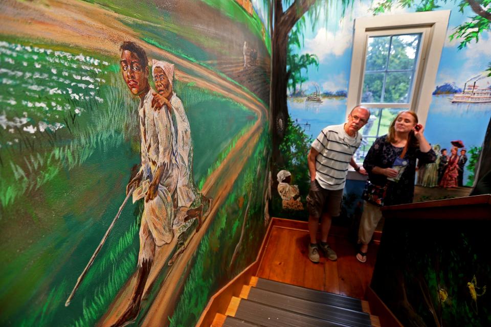 Gib Schmidt, left, and his wife, Sis, look at a mural created and painted by Milton teacher and artist Larry Schultz. The mural shows passages and scenes depicting the Underground Railroad at the Milton House Museum. The national historic landmark is the only authentic Underground Railroad site in Wisconsin that is open for tours.