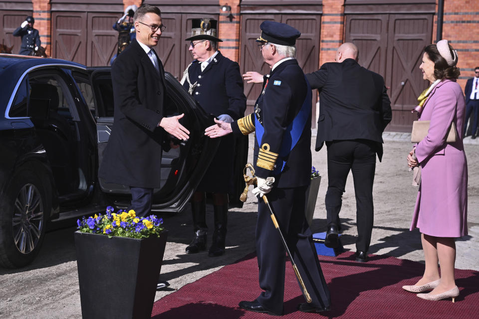 President of Finland Alexander Stubb, left, is welcomed by Swedish King Carl Gustaf, center and Queen Silvia, right, on the occasion of Stubb's two-day visit to Sweden, at the Royal Stables, in Stockholm, Tuesday, April 23, 2024. (Claudio Bresciani/TT News Agency via AP)