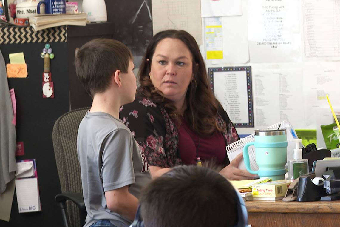 Third grade teacher Bekah Noel talks to a student between lessons at Highland Elementary School in Columbus, Kansas, in April. Three years after the pandemic’s start, Noel has more students than ever reading below grade level. Even though the rural school resumed in-person class during the pandemic, Noel says students missed out on crucial instruction because of limitations on teaching them in small groups. Nicholas Ingram/AP