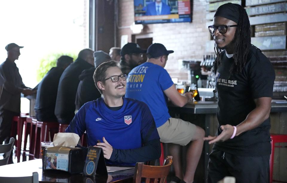 Nov 9, 2022; Phoenix, Ariz., U.S.;  U.S. Supporter Ben Federspiel (left), talks with Jamara Saah, president of American Outlaws Phoenix, at Walter Station Brewery in Phoenix, during a watch party for the announcement of the USMNT World Cup roster.