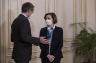 Greek Prime Minister Kyriakos Mitsotakis, left, welcomes French Defense Minister Florence Parly, during their meeting in Athens on Monday Jan. 25, 2021. Greece signed a 2.3 billion euro ($2.8 billion) deal with France Monday to purchase 18 Rafale fighter jets to address tension with neighbor Turkey. (AP Photo/Petros Giannakouris)