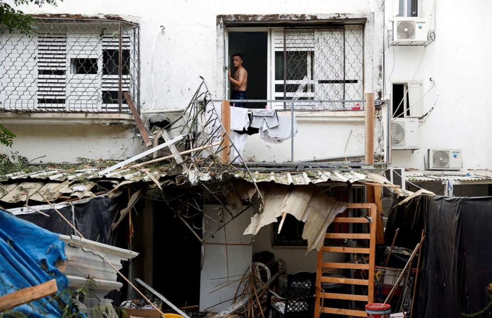 PHOTO: An Israeli man looks out from a window of a building that was hit following rockets from Gaza that were launched towards Israel in Ashkelon, southern Israel, Oct. 9, 2023. (Amir Cohen/Reuters)